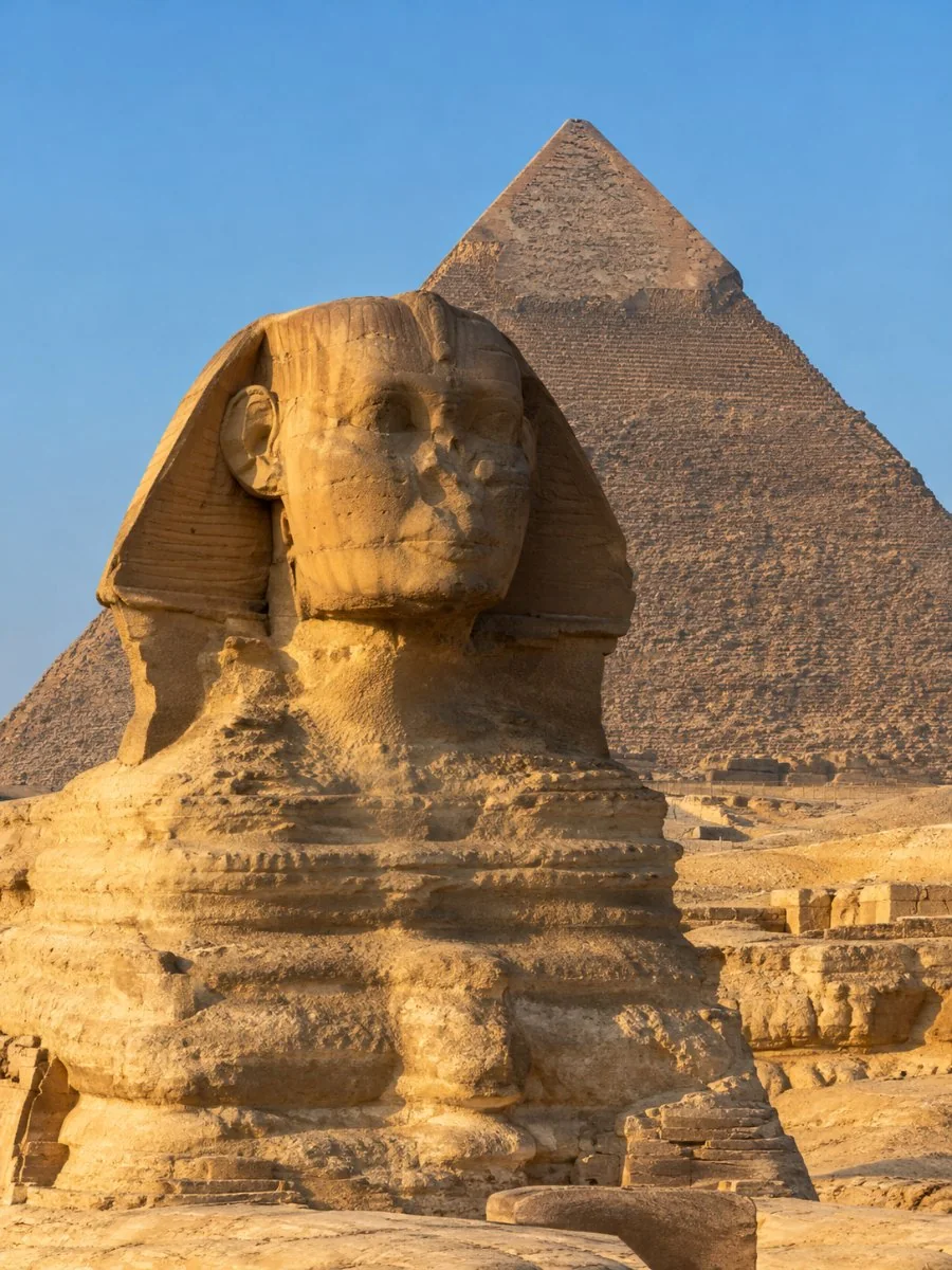 The Great Sphinx of Giza in golden late-afternoon light, with the Pyramid of Khafre rising behind it